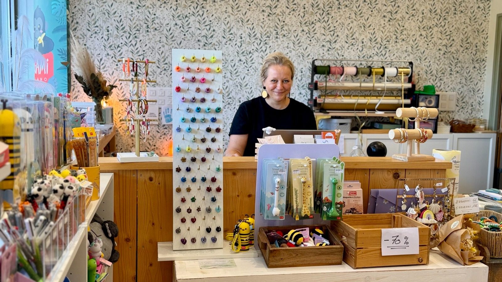 Cécile derrière le comptoir de La Richebourgeoise, entre les rubans et le coin enfants