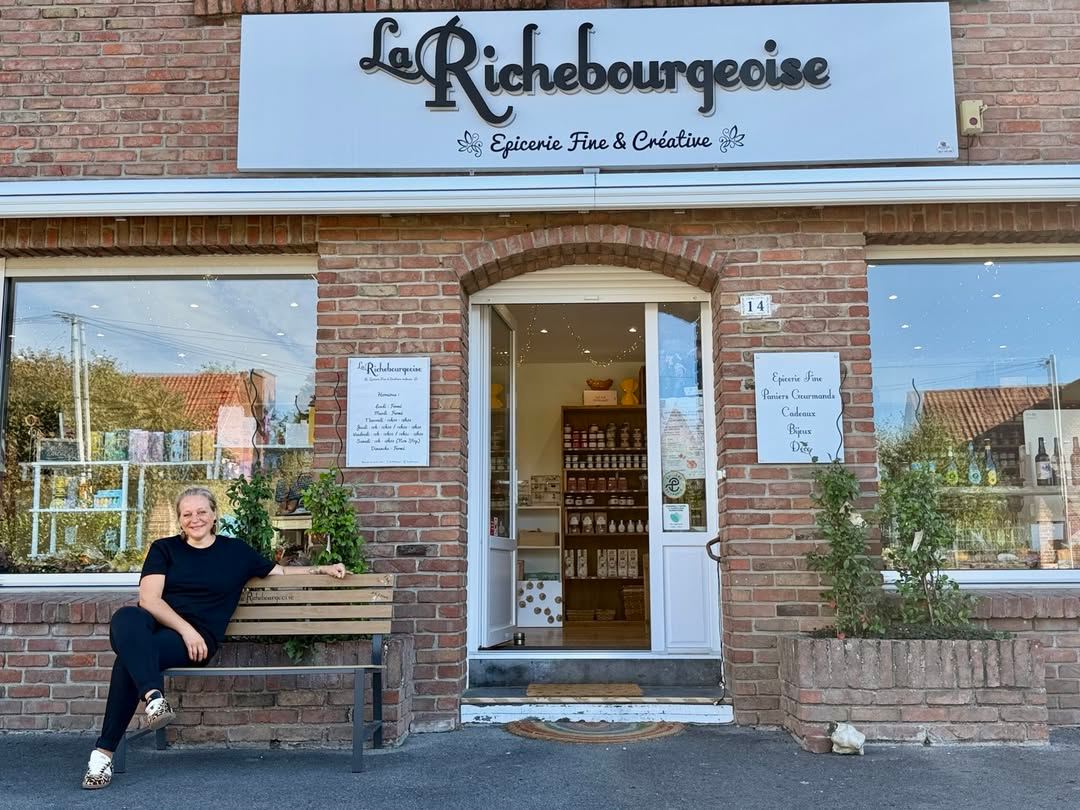 La façade en briques de La Richebourgeoise, avec son enseigne et son banc