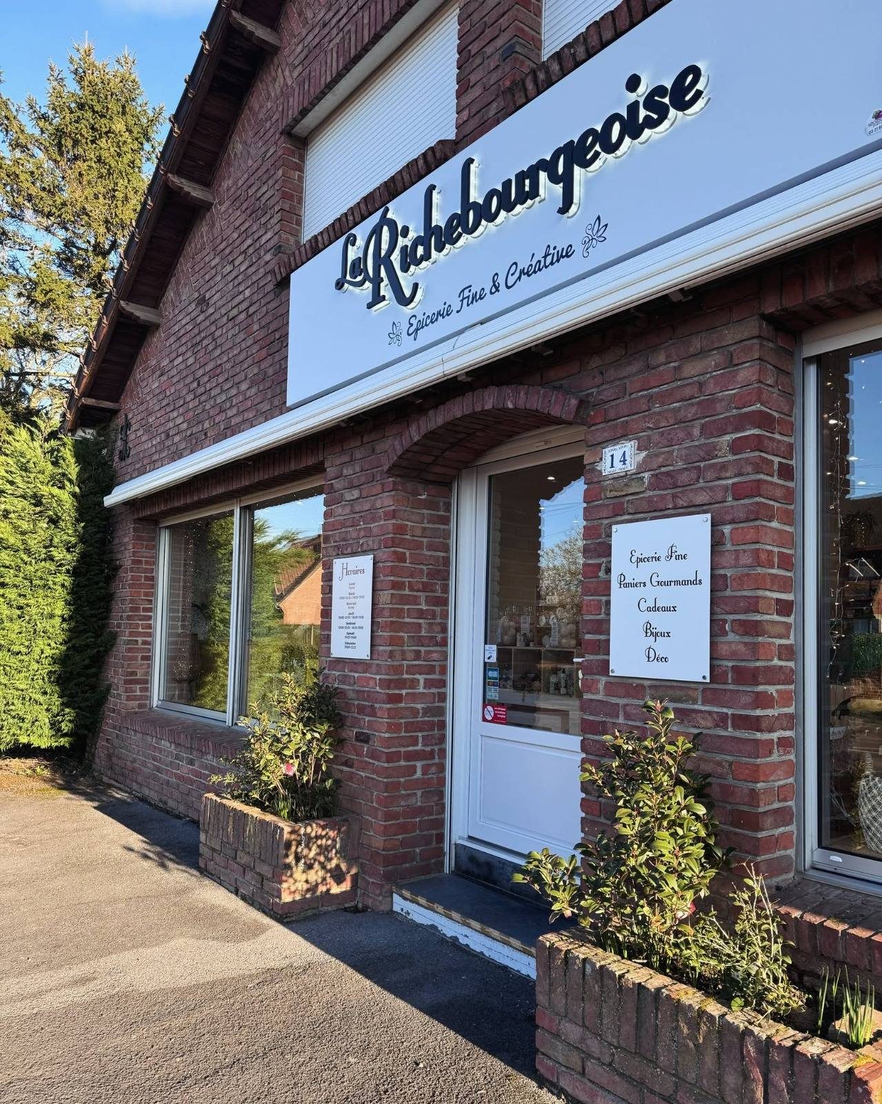 La façade en briques de La Richebourgeoise, son enseigne blanche et le numéro 14 à côté de la porte